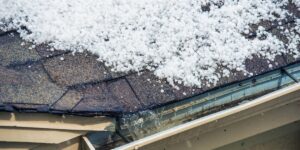 Melting snow running off into the gutter of a house.
