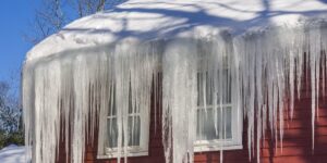 A flood of frozen icicles create an overhang from the roof of a home.