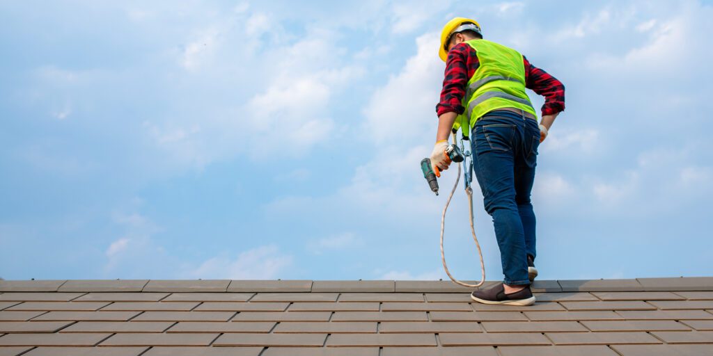 Alt Image Tag: Workers fixing roof tiles.