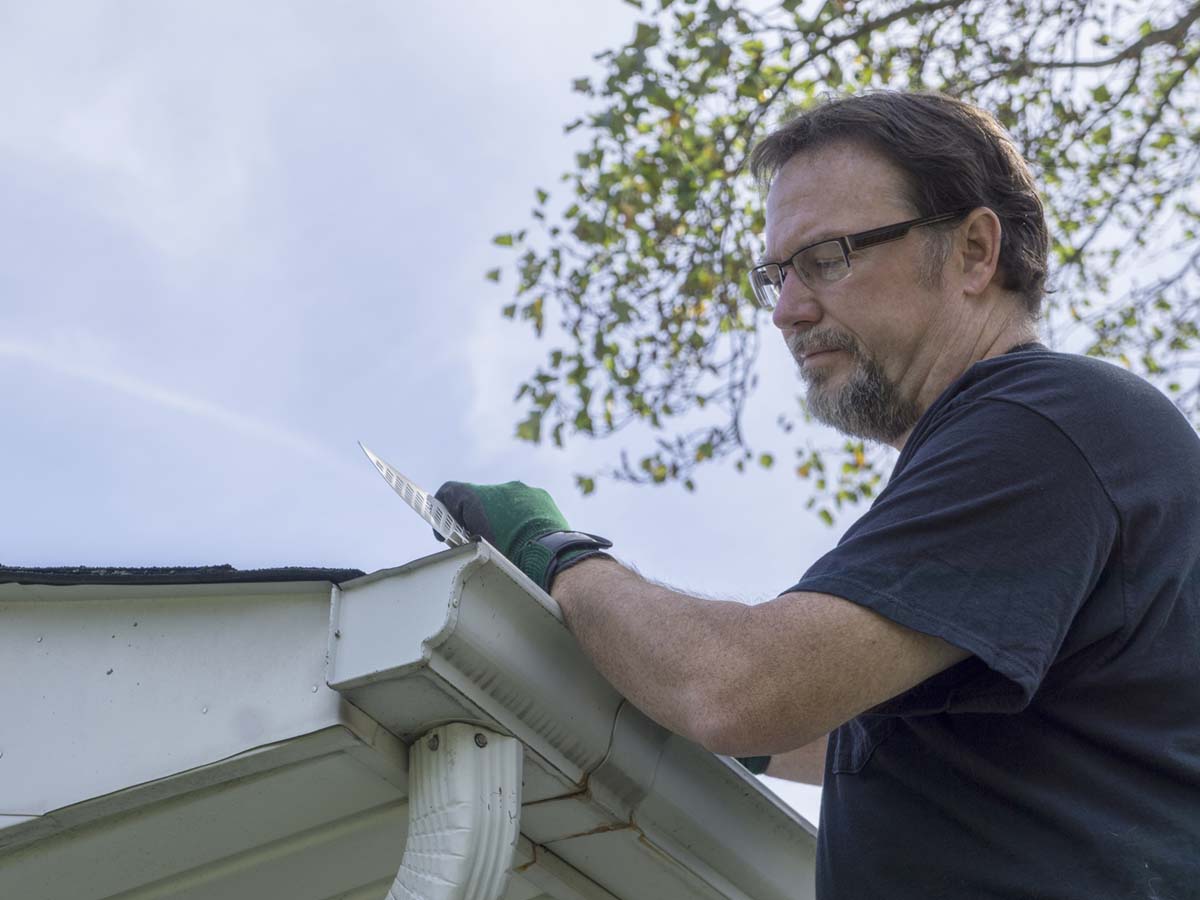 man working on gutters
