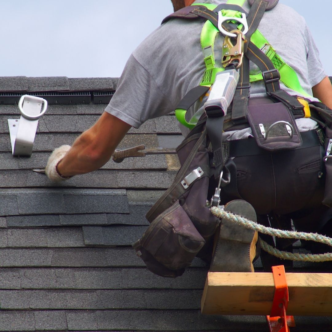 A roofing contractor performing hail damage repairs on a roof