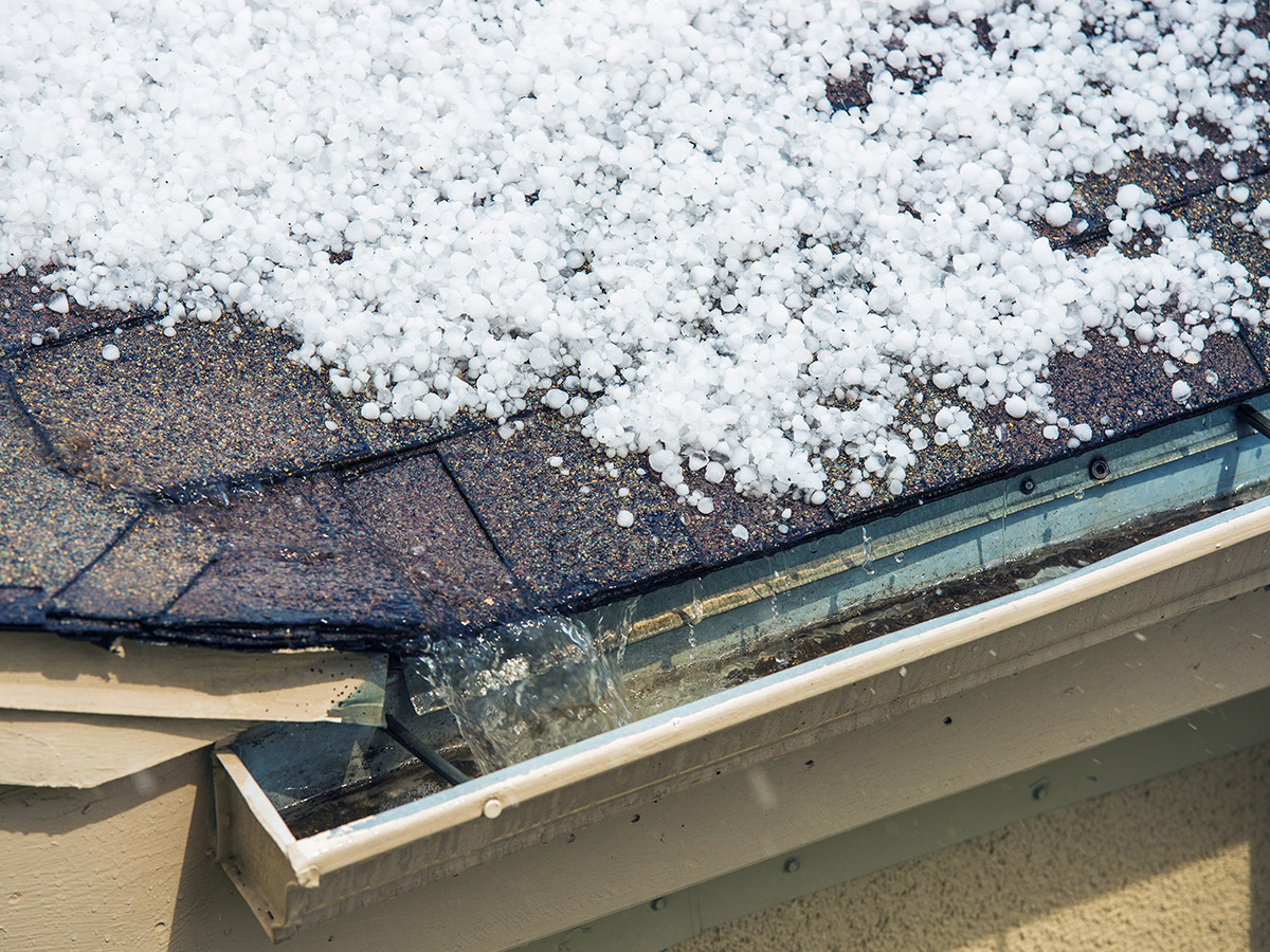Hail that has piled up on a roof near a rain gutter