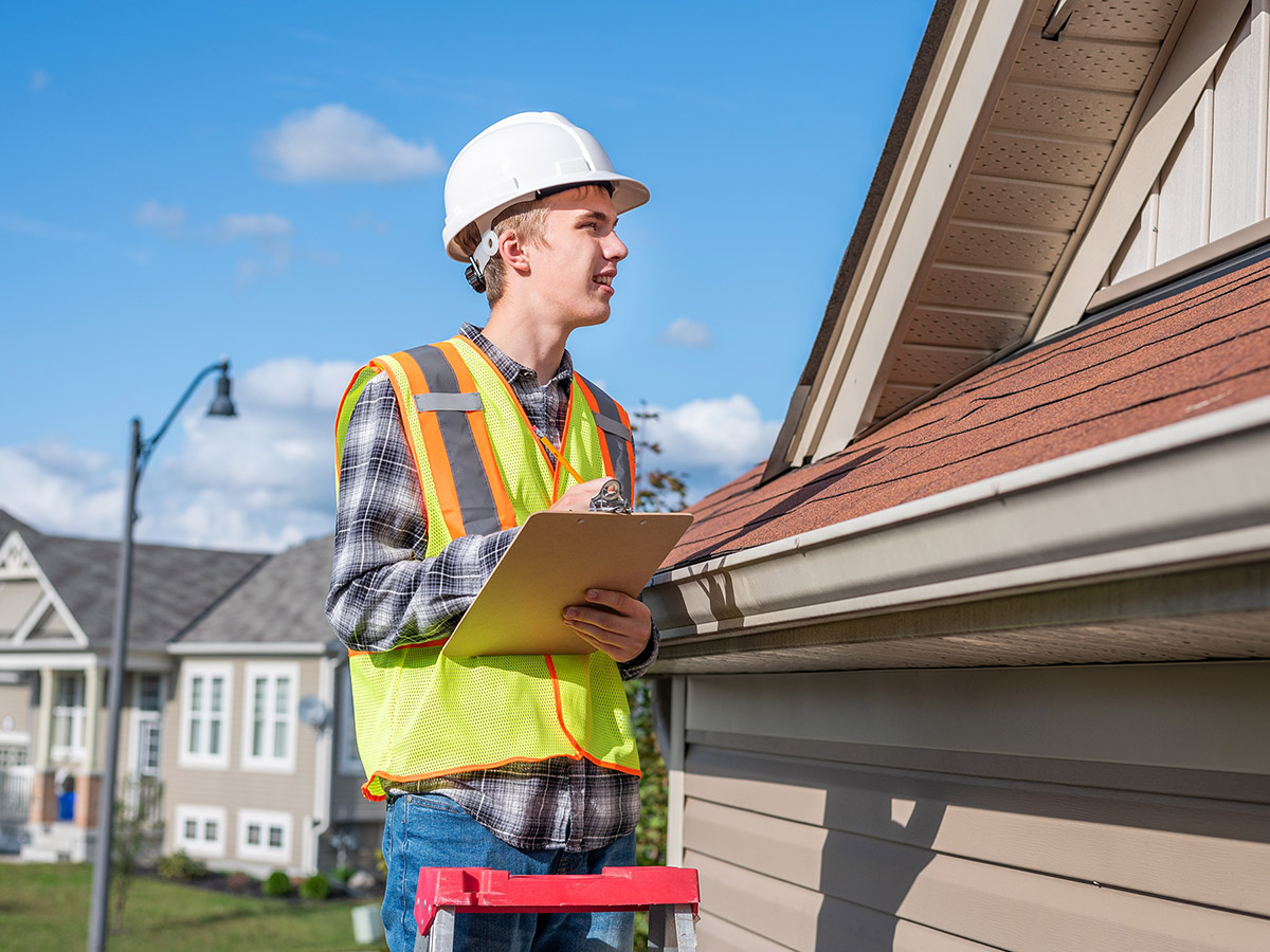 A professional inspecting a home's roof