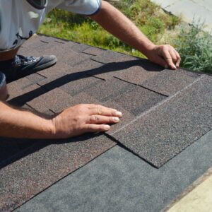 man installing new roof shingles