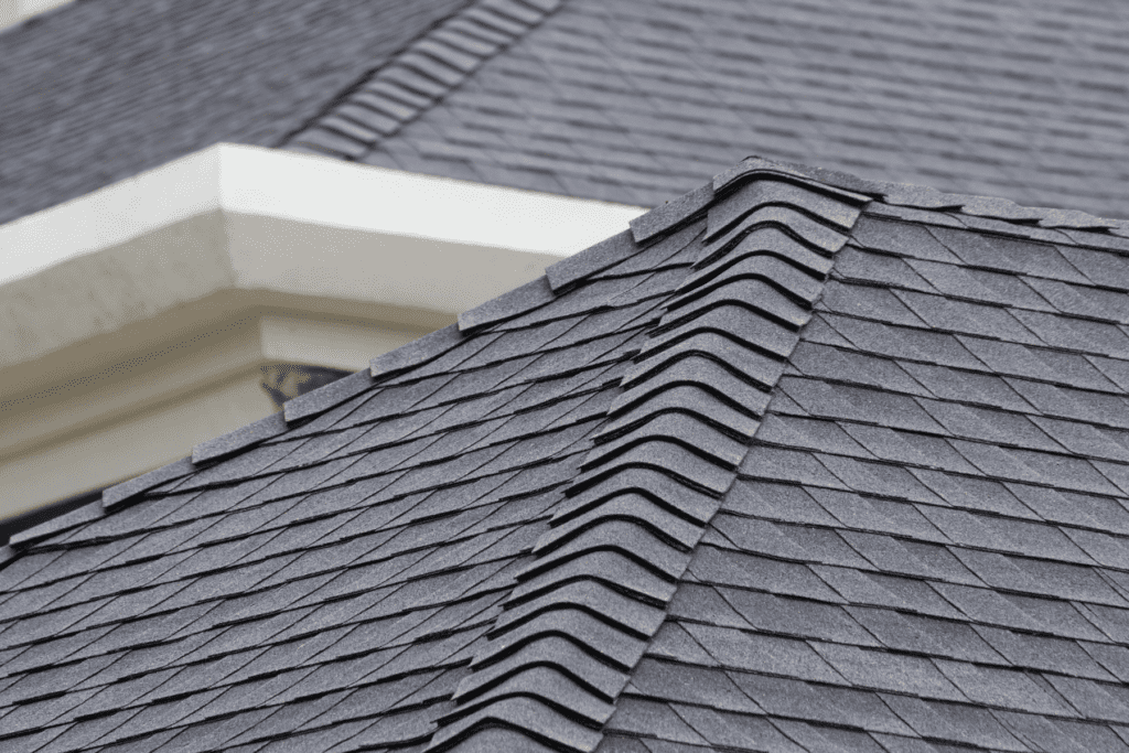 Medium close up of dark grey asphalt shingles on a residential roof.